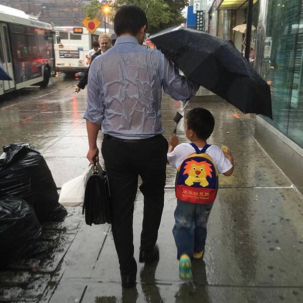 Отец поделился зонтиком с сыном